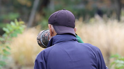 公園で野鳥を撮影するシニアのカメラマン