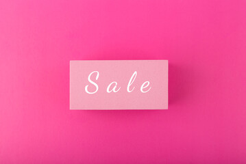 Sale elegant minimal colorful concept. Single word sale hand written on pink tablet in the middle of saturated pink background