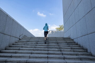 Fitness sports woman running up stairs in city