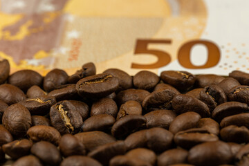 Roasted coffee beans together with 50 euro bill. High price of coffee. Pictute taken in good artificial light.
