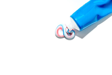 Dented blue tube with squeezed out toothpaste in white, red and blue lies on white background....