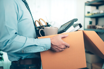 Unemployed hold cardboard box and resignation letter, dossier, alam clock, coffee cup, calculator...