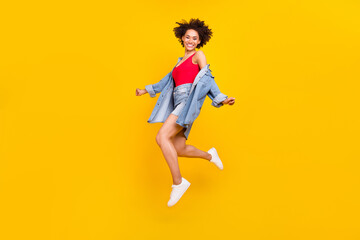 Fototapeta na wymiar Photo of cheerful dreamy lady jump fly wear denim jacket mini skirt sneakers isolated yellow color background