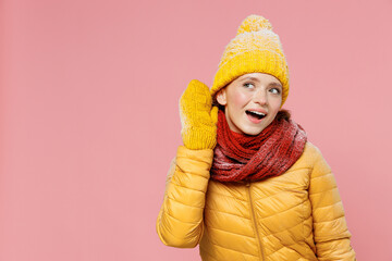Curious nosy fun exultant energetic young woman 20s years old wear yellow jacket hat mittens try to...