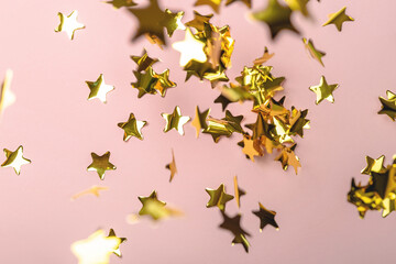Fototapeta na wymiar Background with flying gold confetti stars. Pink background. Wallpaper. 