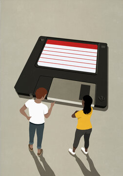 People looking at floppy disk
