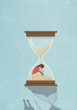 Sand falling over woman inside hourglass
