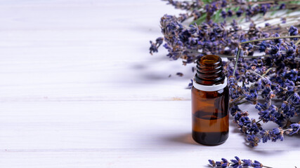 banner, bottle with dropper and lavender flowers on white wooden background, natural cosmetics concept