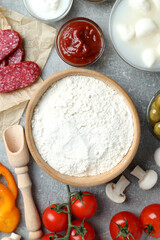 Concept of cooking pizza on gray textured background, top view