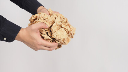 Crumpled brown paper.It is mauled in man hand on white background.