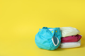 Reusable diapers on yellow background, close up