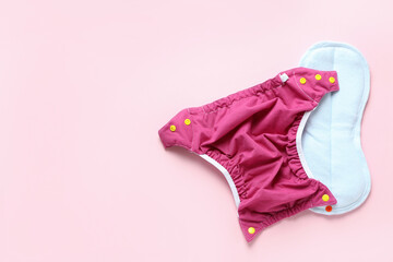 Reusable diapers on pink background, close up