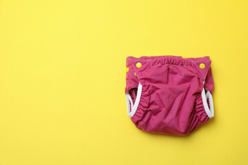 Reusable diapers on yellow background, close up