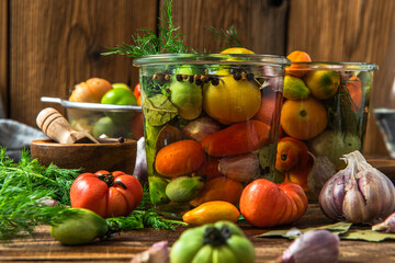 Fototapeta na wymiar Pickled Tomatoes in Jar with Herbs. Healthy Preserved Food
