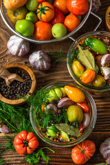 Fototapeta na wymiar Pickled Tomatoes in Jar with Herbs and Garlic