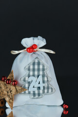 Forth Advent card.Fabric gray gift bag number 24,tree bark star,shiny red balls of decoration like...
