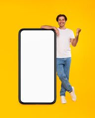 Yes. Man leaning on blank empty cellphone screen celebrating success