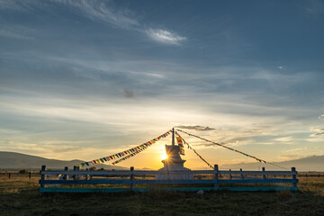 The sun sets behind a Buddhist stupa