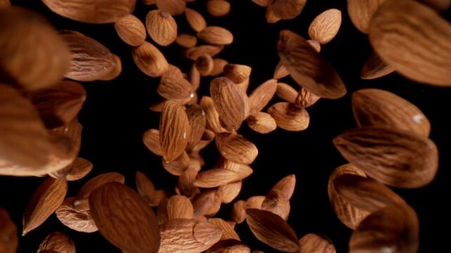Super slow motion of falling almonds pieces, wide super macro shot. Isolated on black background. Filmed on high speed cinema camera, 1000fps.