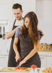 Cheerful couple cooking in kitchen