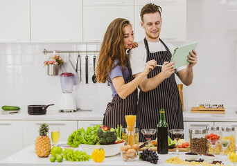 Couple browsing tablet in kitchen - Powered by Adobe