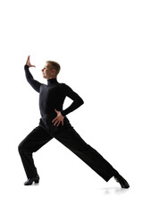 Portrait of young graceful male dancer, flexible man in black stage costume dancing ballroom dance isolated on white studio background.