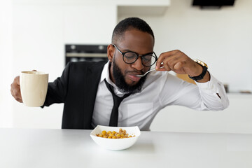 Black man rushing to work eating cereal at home