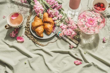 Foto auf Acrylglas Summer picnic with french croissant, cherry blossom tea and fresh cherries on pale textile background. Romantic breakfast scene with pink petals, food and drinks. Top view. © VICUSCHKA