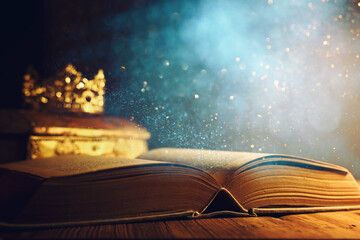 low key image of beautiful queen or king crown and old book. vintage filtered. fantasy medieval...