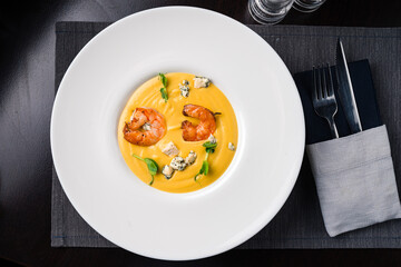 Autumn food pumpkin soup with shrimps. Served for dinner