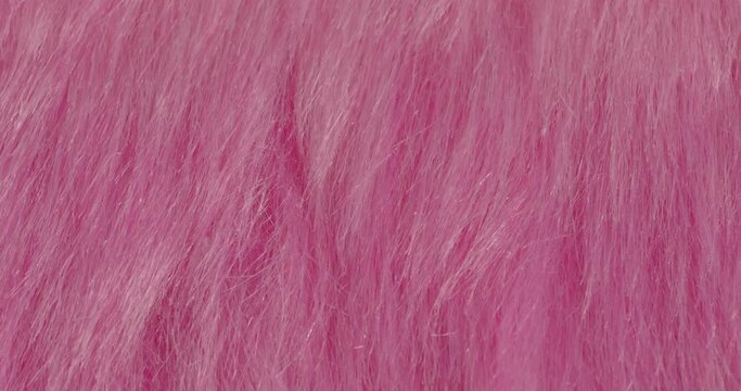 Macro textures of faux fur. Pile close-up. Pink background.