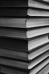 Large stack of books in a black and white photograph.