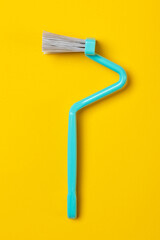 blue Crooked toilet rim brush on yellow background