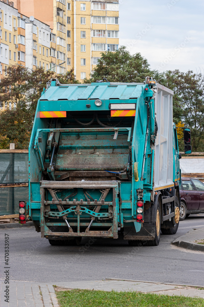 Fototapete A garbage truck picks up garbage in a residential area. Separate collection and disposal of garbage. Garbage collection vehicle.