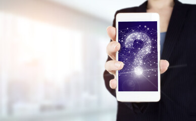 FAQ Concept image.Find answer online. Hand hold white smartphone with digital hologram question mark sign on light blurred background. Business support concept. Problems and solutions.