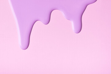 Light lilac liquid drops of paint color flow down on pink background. Abstract purple backdrop with...