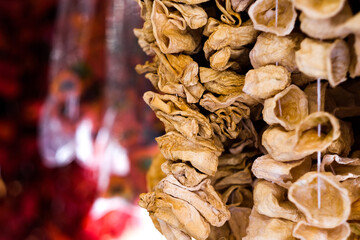 Dried eggplants hanging on threads for sell, selective focus
