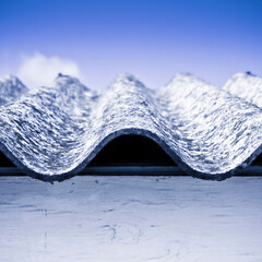 Old aged dangerous roof made of corrugated asbestos panels - one of the most dangerous materials in...