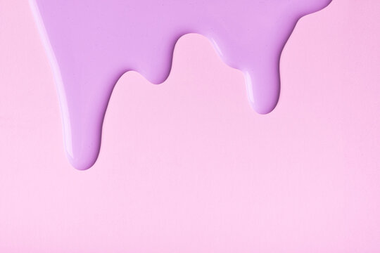 Light lilac liquid drops of paint color flow down on pink background. Abstract purple backdrop with fluid drip pattern.