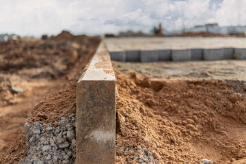 Pavement repair and laying of paving slabs on the walkway, stacked tile cubes on the background. Laying paving slabs in the pedestrian zone of the city, sand filling. Road tiles and curbs.