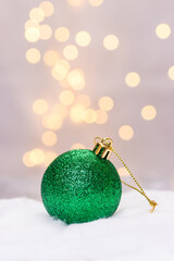 green christmasball decoration infront of golden bokeh with copy space