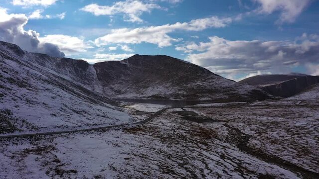 Summit Lake in Mount Evans Area. Snowy Mountains and Road. Cloudy Sky. Aerial View. Colorado, USA. Drone is Orbiting