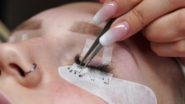 Eyelash extension procedure. Woman eye with long eyelashes. Eyelashes, close-up, macro, selective focus. 4K