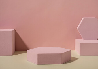 Pink geometrical shapes on sandy floor against the wall