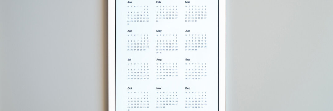 tablet computer with an open app of calendar for unspecified unknown date year without date on a gray background. concept business or to do list goals with technology using. top view, flat lay. banner