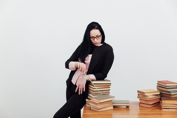 beautiful brunette woman in a business suit teacher with books at the table