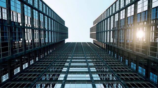 Sunlight reflecting off glass skyscrapers as the camera moves from ground level up to the clear blue sky above.