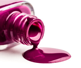 Colorful purple nail polish pouring out from bottle