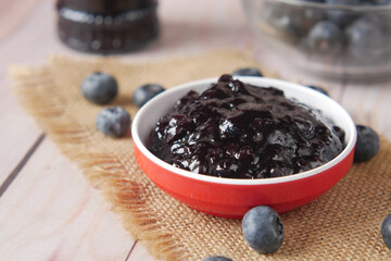 blue berry jam in container on table 