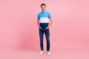 Fototapeta na wymiar Full length photo of cool brunet young guy stand wear polo jeans sneakers isolated on pink background